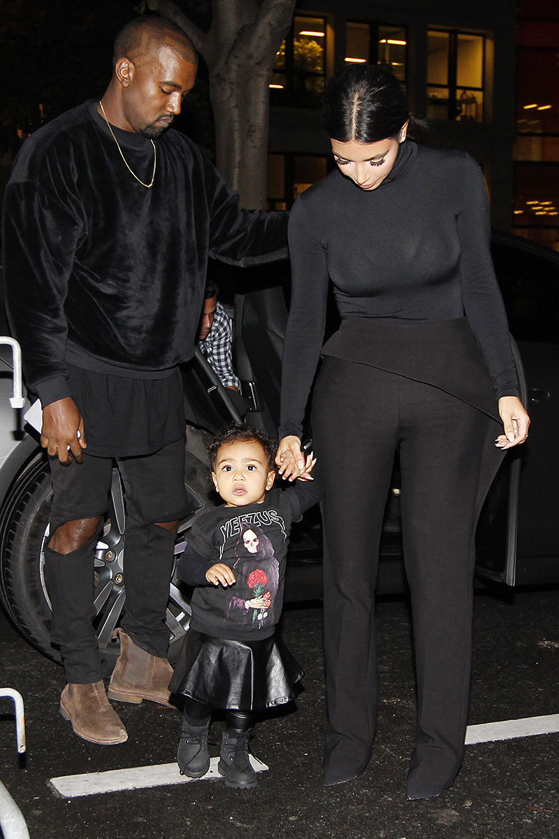 Kanye West, Kim Kardashian and their daughter North West walk to the Balenciaga Womenswear Spring/Summer 2015