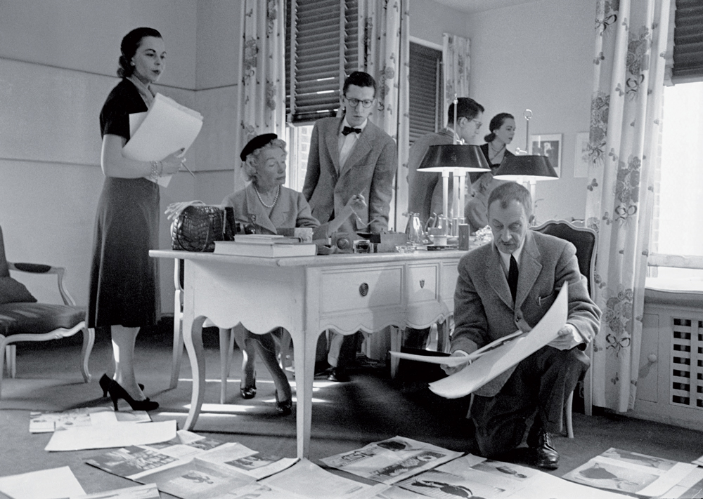 Tổng biên tập Carmel Snow (ngồi) cùng hai trợ lý và giám đốc mỹ thuật Alexey Brodovitch (quỳ) đang xem xét lại layout bài vở (ảnh chụp tháng 12–1952). Ảnh: GETTY IMAGES 