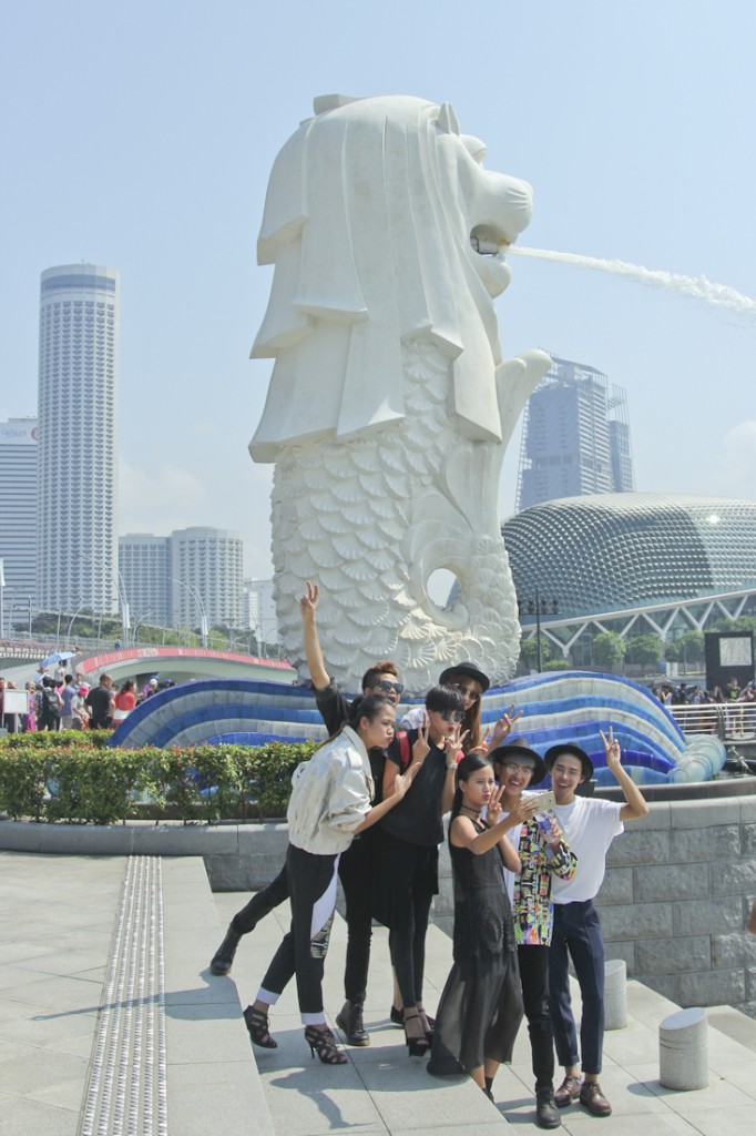 Các thí sinh chụp ảnh wefie trước biểu tượng sư tử biển của Singapore tại Merlion Park 