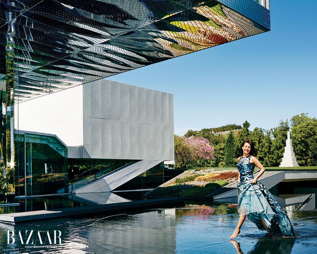 Ngoại cảnh thép không rỉ của căn nhà, được thiết kế bởi kiến trúc sư Michael Maltzan, hứng lấy ánh phản chiếu từ hồ nước bên dưới. Mellon mặc váy Carolina Herrera 