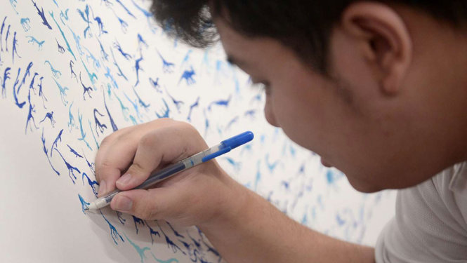Chàng trai tự kỷ See Toh Sheng Jie đang phát hoạ những hình vẽ khủng long 
