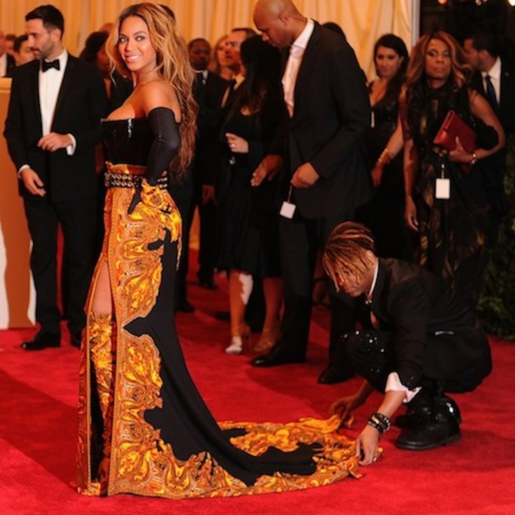 Ca sĩ Beyoncé được stylist Ty Hunter sửa váy trên thảm đỏ.