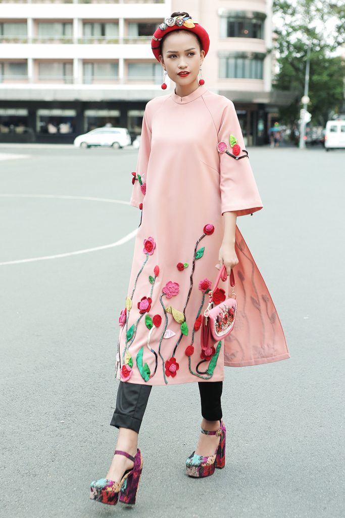 Áo dài cách điệu màu hồng pastel kết hợp cùng quần ôm và phụ kiện mang lại vẻ hiện đại, cá tính