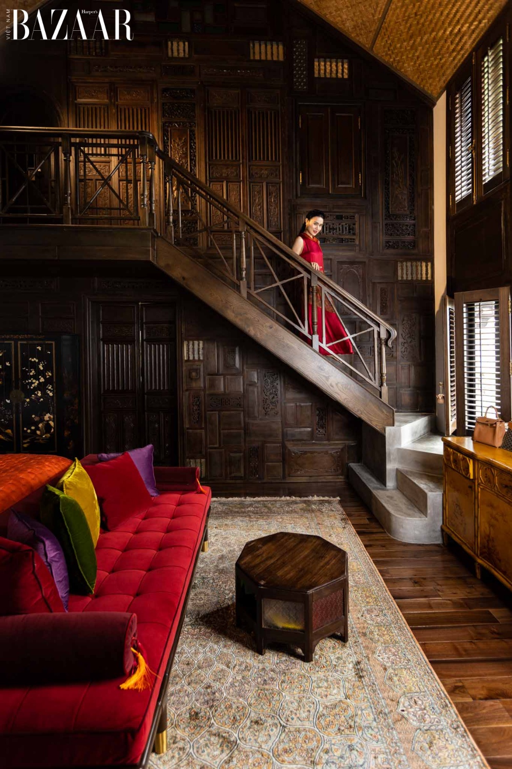 Phòng ngủ theo phong cách Indochine sử dụng tường gỗ, sofa vải nhung đỏ tạo sự sang trọng, quý phái cho không gian