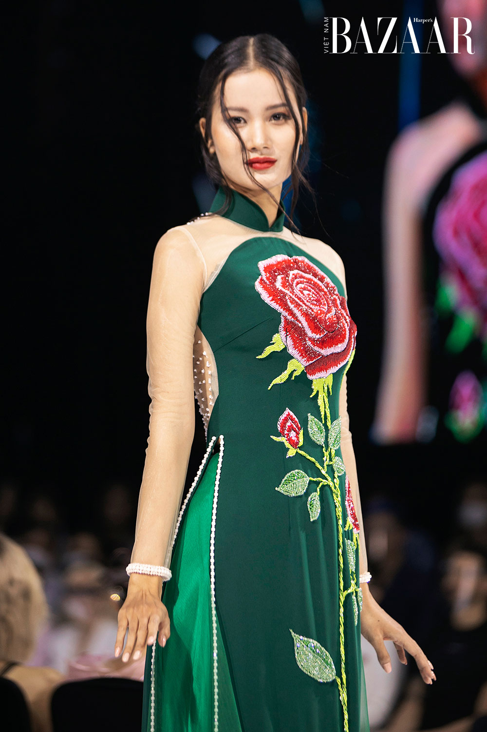 Người mẫu Hương Ly - Quán quân Vietnam's Next Top Model 2015 thướt tha trong thiết kế màu xanh lá với điểm nhấn là bông hoa hồng đỏ rực được đính kết lấp lánh