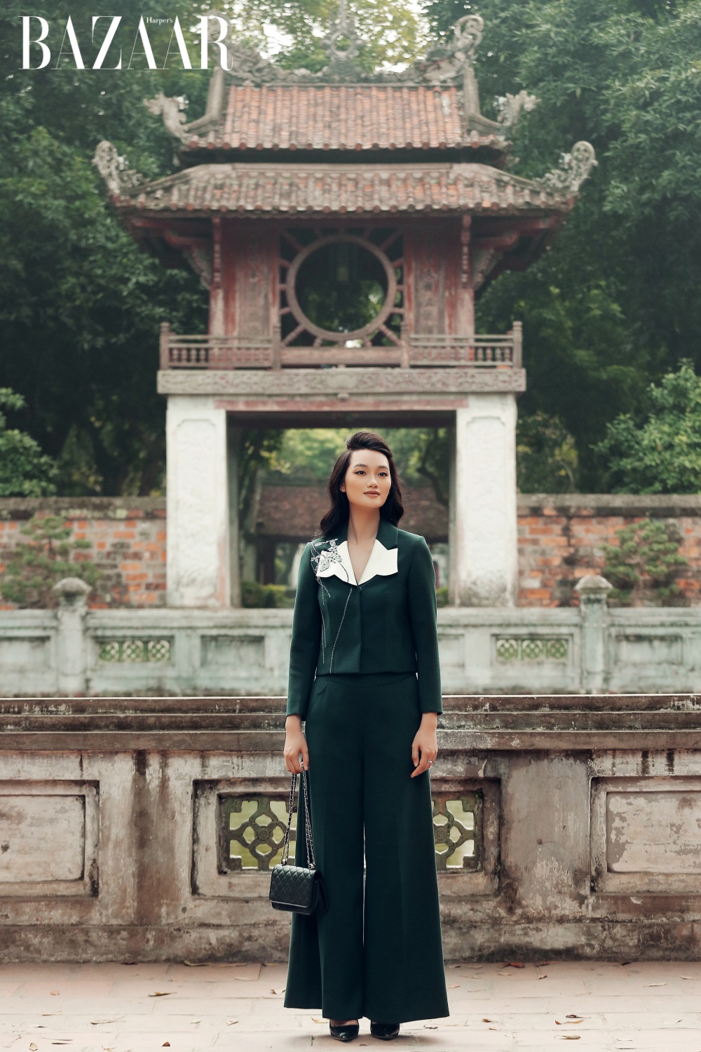 Văn Miếu Quốc Tử Giám làm nền cho trang phục mang sắc xanh đậm, lấy cảm hứng từ hàng cây trên phố Phan Đình Phùng. 