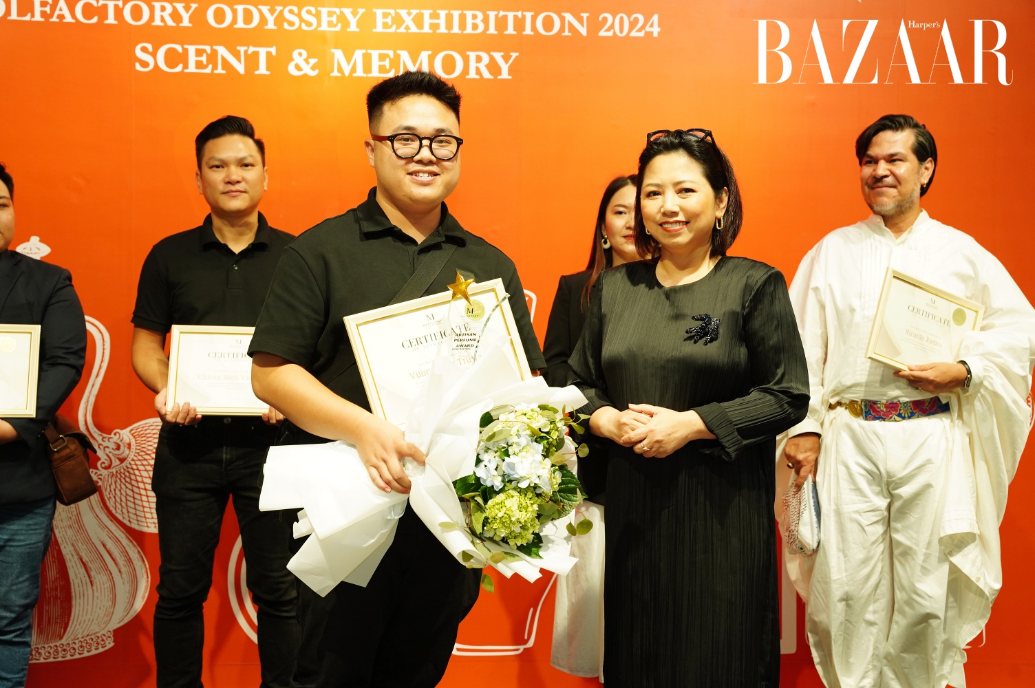 Perfumer Huỳnh Hải Yến (trái) – Nhà đồng sáng lập MetaScent, Trưởng BTC Olfactory Odyssey Exhibition 2024 – trao chứng nhận và cúp vinh danh Artisan Perfume cho tác giả Vương Trần Trung.