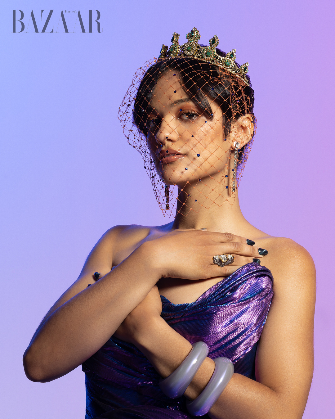 Diễn viên Marissa Bode, ngôi sao nổi lên từ bộ phim Wicked, mặc đầm tím, đầu đội vương miện và che mạng.