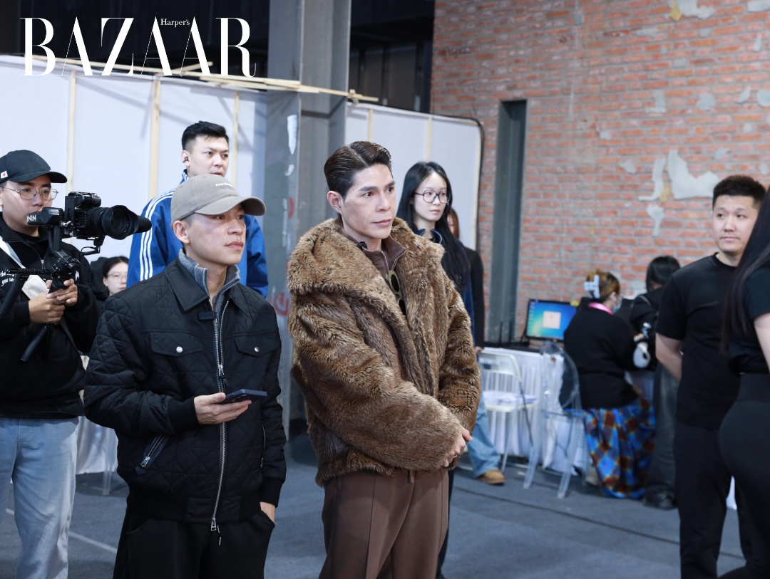 Đạo diễn Nguyễn Hưng Phúc và Nhà thiết kế Adrian Anh Tuấn của Valenciani (đội nón) tại hậu trường Tuần lễ Thời trang Cáp Nhĩ Tân. 