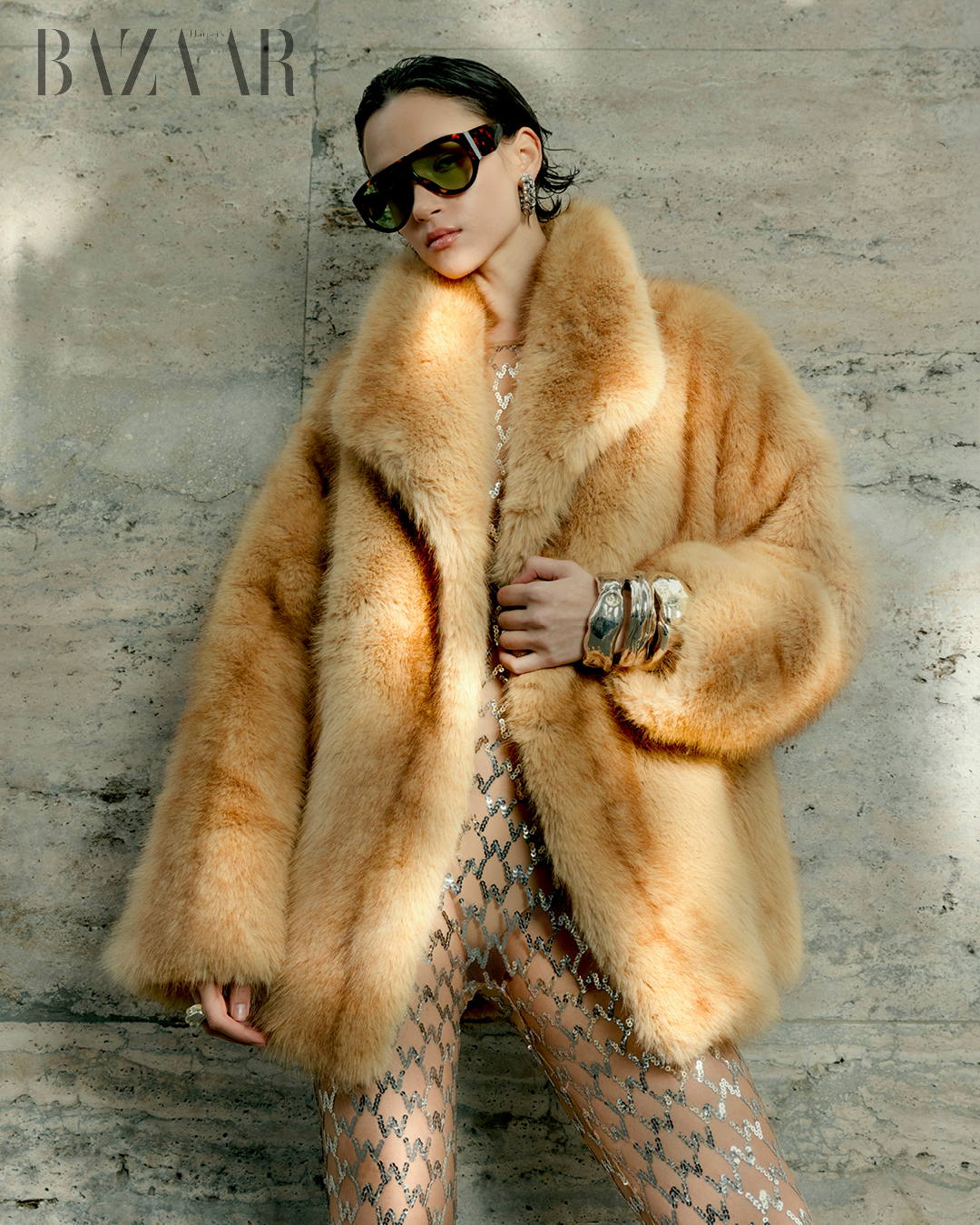 Áo khoác lông giả: Cesare Gaspari. Bộ jumpsuit: của stylist. Giày: Giaborghini. Kính mát: Stradivarius. Nhẫn và vòng tay: Atelier Or.Ti.Ca